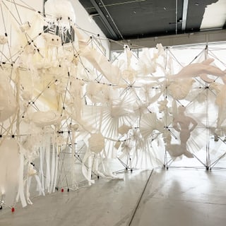 Moderne Kunstinstallation mit weissen Skulpturen in einem Raum.