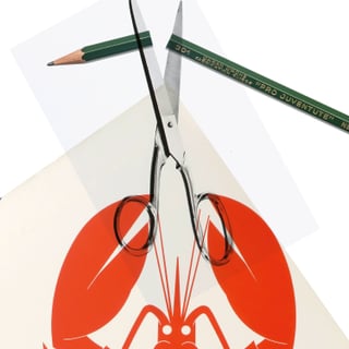 Schere schneidet rotes Hummerbild mit grünem Stift oben.