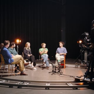 Personengruppe in Studio mit Kameramann im Vordergrund.