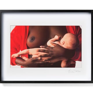 Fotografie einer Frau, die ein Baby stillt, im schwarzen Rahmen.