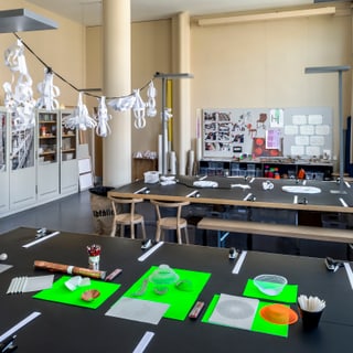 Kunstklassenzimmer mit Bastelmaterialien auf Tischen.