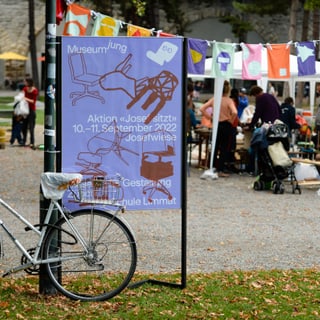 Fahrrad vor Plakat des museumjung auf einer Veranstaltung im Freien.