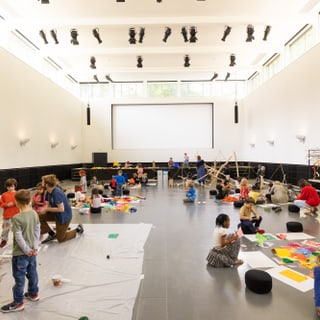 Kinder basteln und malen in einem grossen Raum.