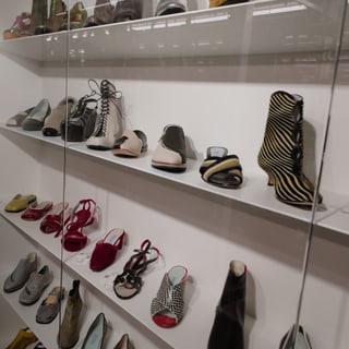 Display von diversen modischen Schuhen in einem Regal.