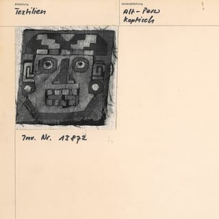 Archivkarte mit einer schwarz-weiss Abbildung eines antiken peruanischen Textils mit Gesichtsmuster.