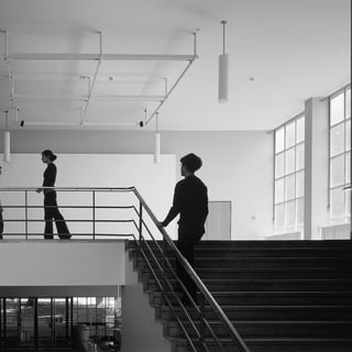 Menschen auf einer Treppe in einem modernen Gebäude.