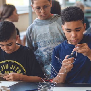 Kinder basteln konzentriert im Klassenzimmer.