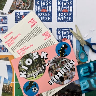 Schreibtisch mit Bastelmaterialien und Grusskartenentwürfen.