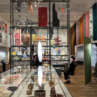 Museumsausstellung mit modernen Kunstwerken und Textilien an den Wänden.