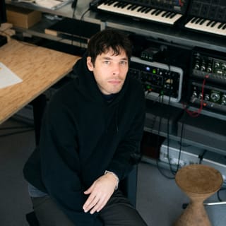 Person in Tonstudio mit Musikausrüstung.