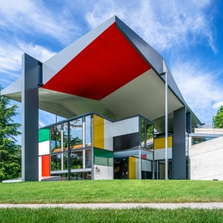 Bunte moderne Architektur mit Grasvordergrund und blauem Himmel.