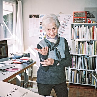 Lora Lamm in Büro mit Büchern und Schreibtischrechner.