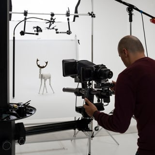 Fotograf macht ein Bild von einer kleinen Statue in einem Studio.