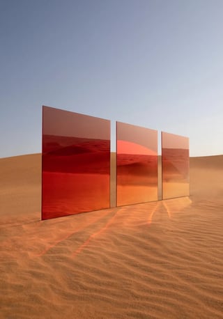 Drei spiegelnde Tafeln in der Wüste reflektieren den Himmel und Sanddünen.