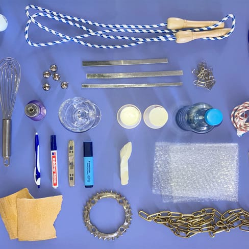 Verschiedene Alltagsgegenstände auf blauem Hintergrund angeordnet.