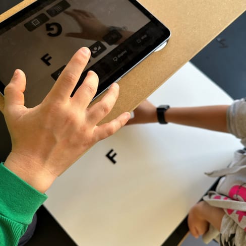 Eine Person scannt einen Buchstaben mit einem Tablet.