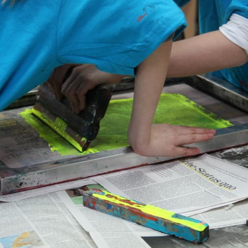 Personen beim Siebdruck auf Papier mit Farbe.