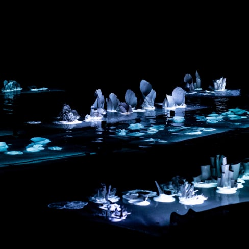 Abstrakte leuchtende Skulpturen im Dunkeln.