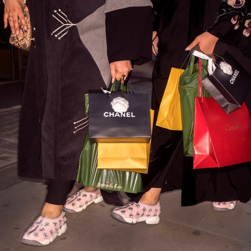 Frauen halten Einkaufstaschen von Luxusmarken auf der Strasse.