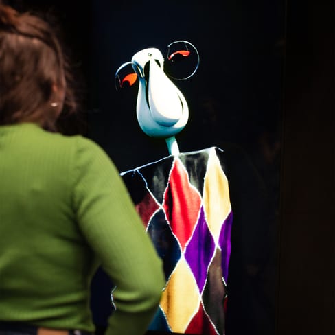 Person betrachtet digitales Kunstwerk mit buntem Harlekin-Muster.