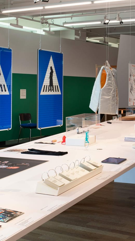 Ausstellungstisch mit verschiedenen Objekten und Schildern.