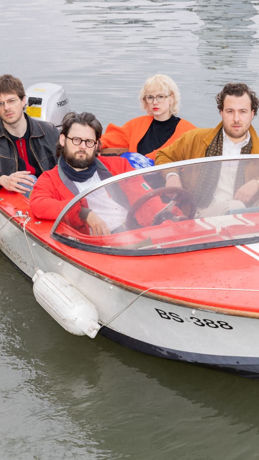 Vier Personen in kleinem Boot auf dem Wasser.