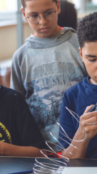 Kinder basteln konzentriert im Klassenzimmer.