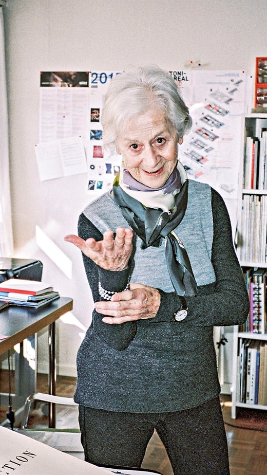 Lora Lamm in Büro mit Büchern und Schreibtischrechner.