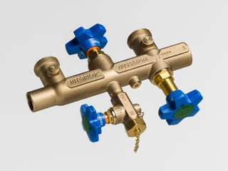 Messingventil mit blauen Griffen auf grauem Hintergrund.