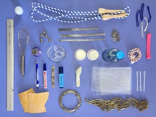 Verschiedene Alltagsgegenstände auf blauem Hintergrund angeordnet.
