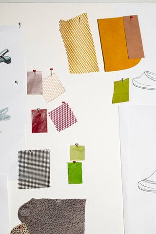 Wand mit bunten Stoffproben und Zeichnungen.