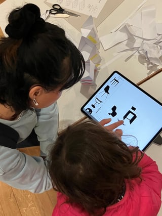 Frau und Kind betrachten digitales Design auf einem Tablet.