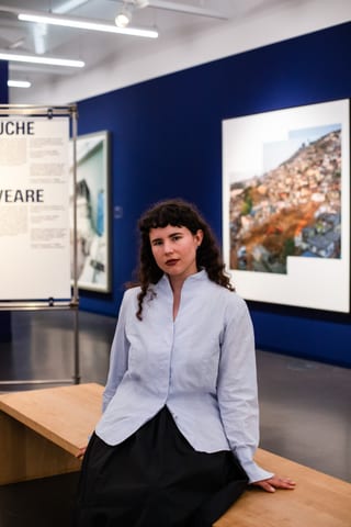 Person in einem Kunstmuseum auf einer Bank sitzend.