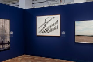 Kunstgalerie mit Bildern an blauen Wänden.
