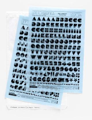 Zwei blaue Schablonen mit geometrischen Formen auf Papierhülle.