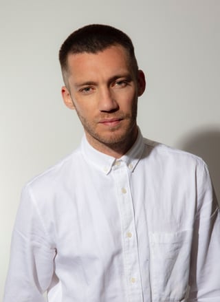 Mann in weissem Hemd vor weissem Hintergrund.
