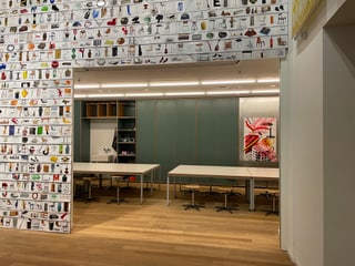 Raum mit dekorativer Wand und Tischen im Inneren eines Gebäudes.