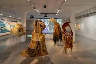 Kunstausstellung mit skulpturalen Gewändern in einem Galerieraum.