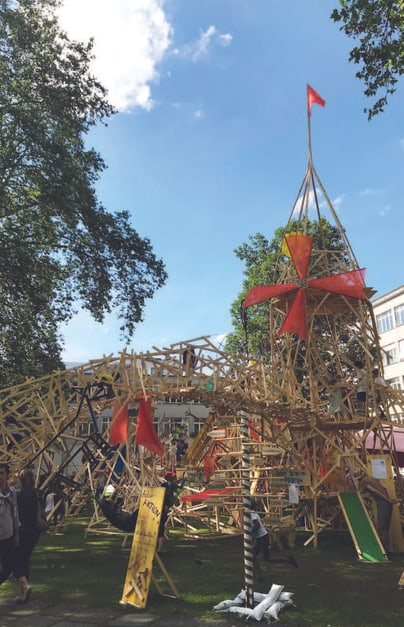 Struktur aus Holz im Freien mit Menschen darum herum.