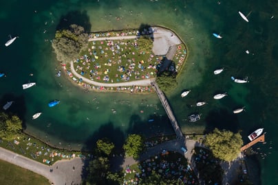 Luftaufnahme von einer Insel mit Park und Booten im Wasser.