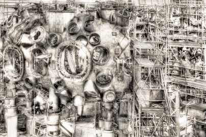 Schwarz-weiss Bild von einem komplexen Maschinenbauwerk mit Gerüsten.