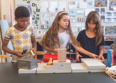 Drei Kinder arbeiten mit Objekten aus den Collection Highlights.