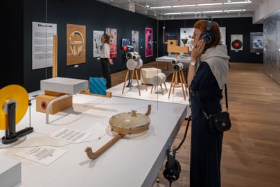 Frau hört Audio in moderner Kunstausstellung.