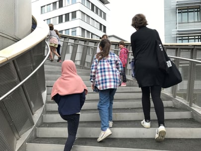 Menschen gehen eine Treppe hinauf im Freien.",