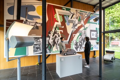 Zwei Personen betrachten Kunstwerk in modernem Ausstellungsraum.