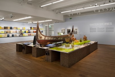 Ausstellung mit Boot im Museum, Wandtext 'WATER STORIES'.