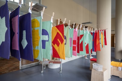 Bunte Stoffbanner hängen an einer Leine zum Trocken im Museum für Gestaltung.