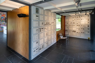 Ausstellungsraum mit gerahmten Kunstwerken an den Wänden.