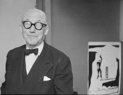 Der Architekt Le Corbusier schwarzer runder Brille und Fliege vor einem seiner Gemälde.