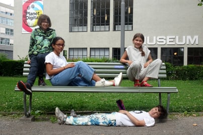 Vier Kinder auf und um eine Parkbank vor dem Museum für Gestaltung an der Ausstellungsstrasse.